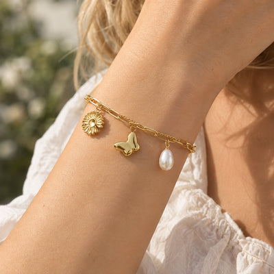Daisy & Butterfly Charm Bracelet — Multi-strand charm bracelet with daisy and butterfly charms (close-up detail)