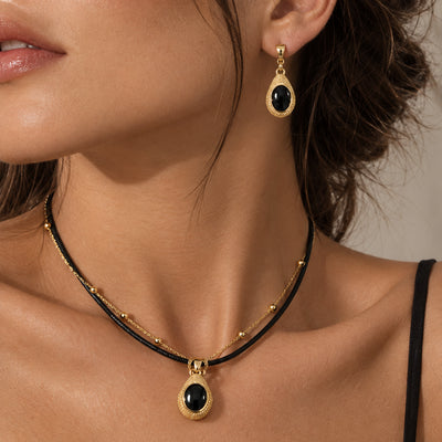 Noir Leather Necklace Set — Two-piece set with a black leather necklace and crystal-set earrings (close-up detail)